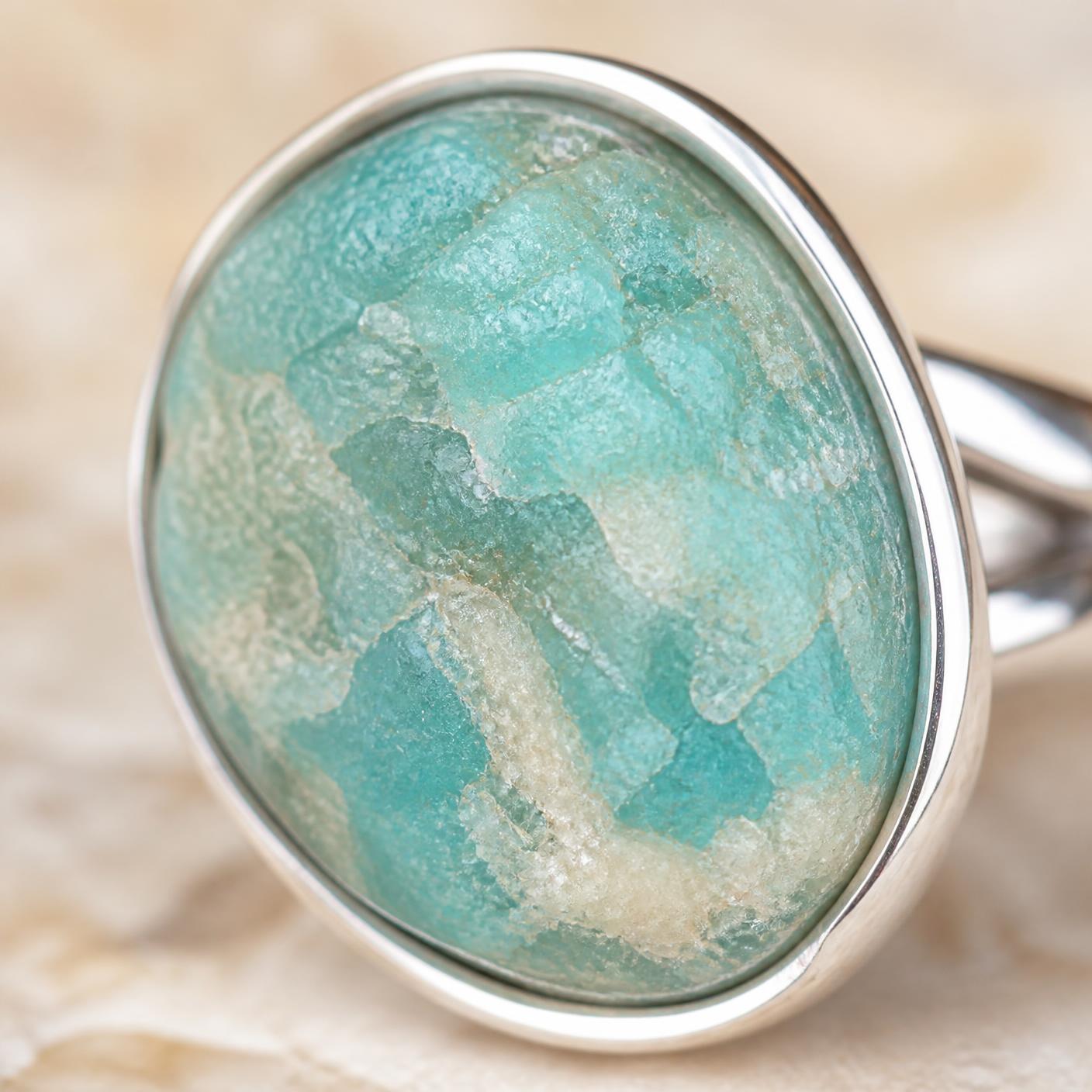 Macro detail of the raw Amazonite stone's mineral texture and cream veining inside the polished silver setting.
